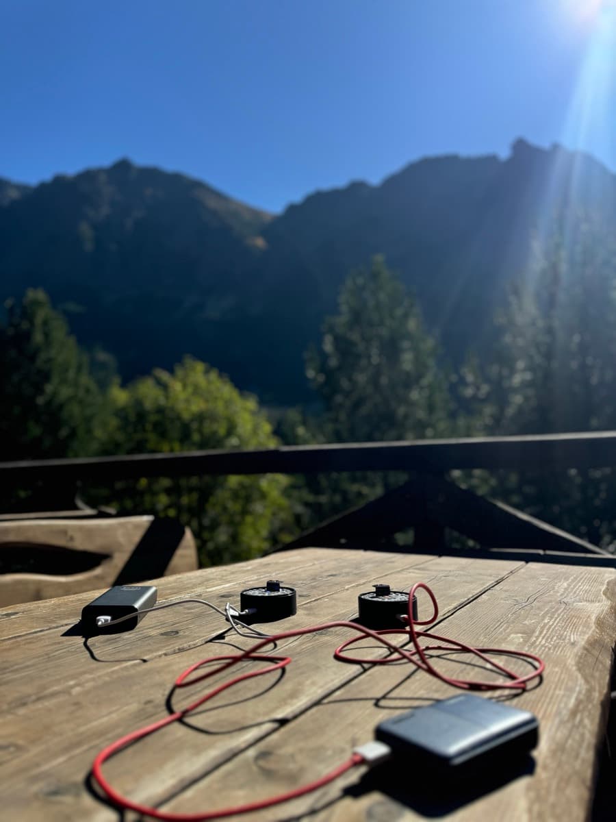aura prototypes charging on a mountain-cabin table
