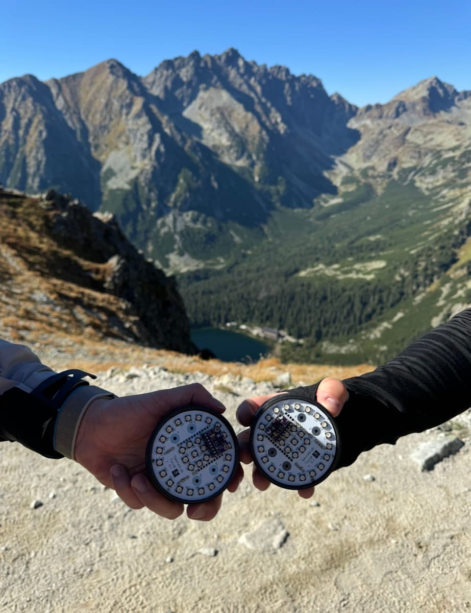 two hands holding open aura prototypes above a tatra valley