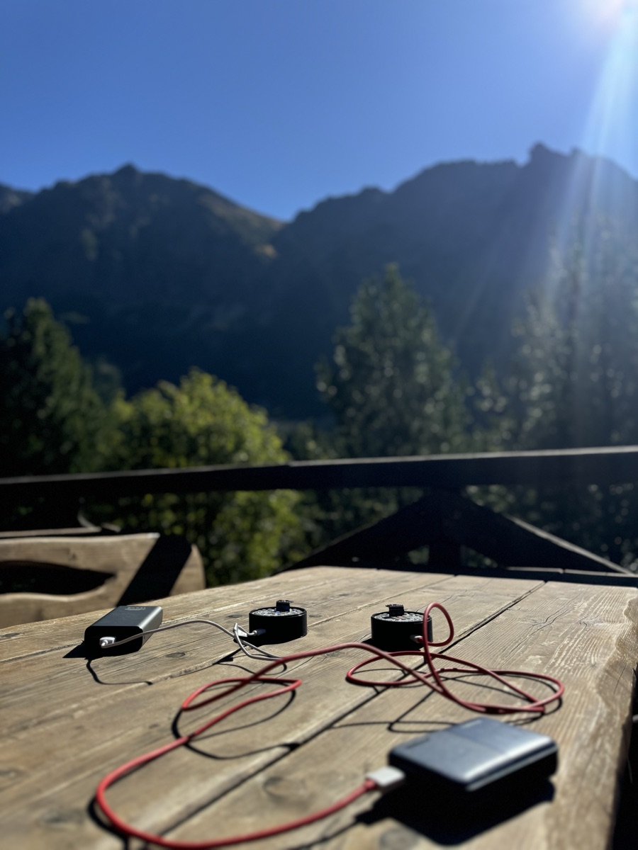 aura prototypes charging on a mountain-cabin table